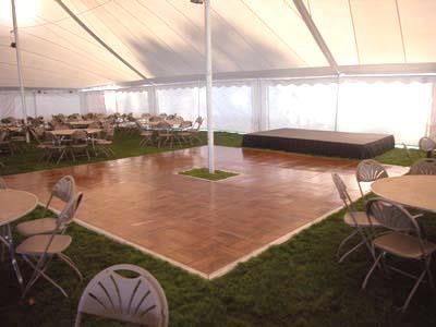 White high peak party tent with dance floor, stage, table and chair rentals set up in Madison Wisconsin